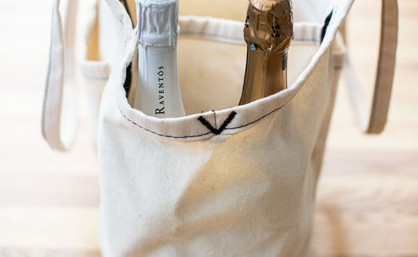 Two bottles of sparkling wine in the end pocket of a Natural Organic Cotton Truck.